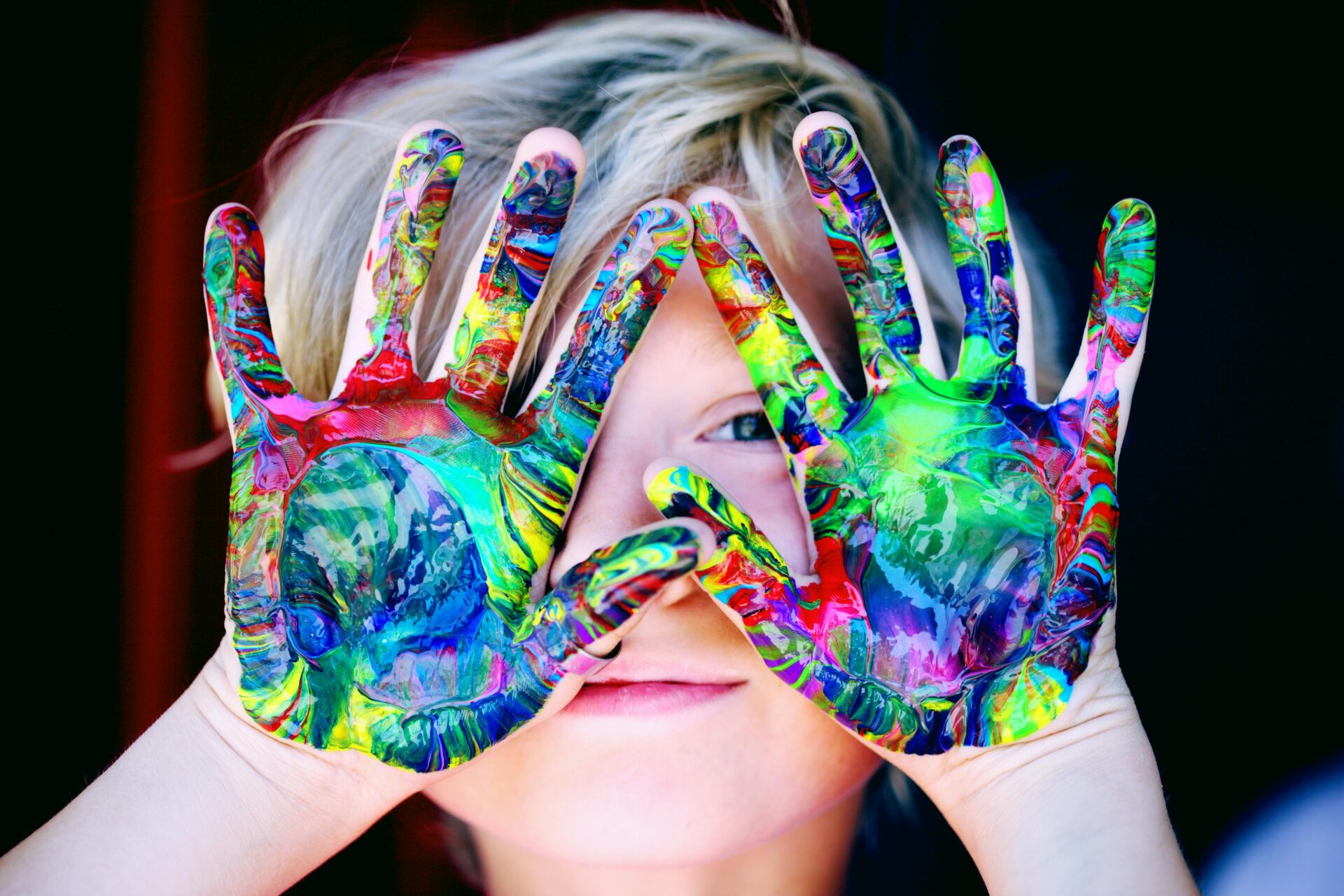 A person with their hands painted in the colors of a rainbow.